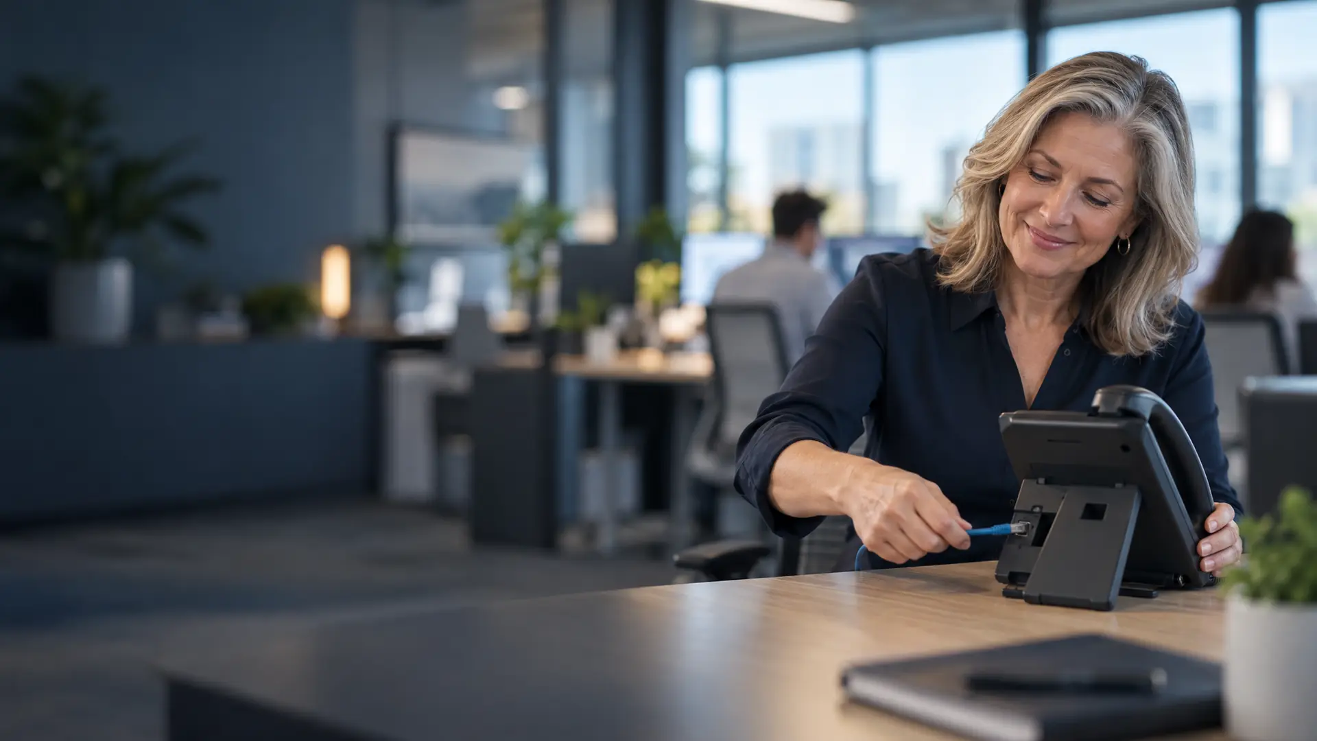 Office manager setting up a VoIP desk phone